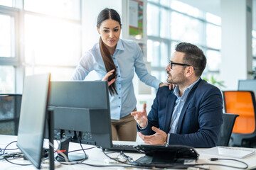 Female and male business colleagues are consulting at computer discussing poor business results