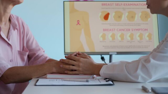 Cropped shot of therapist holding hands of female patient with breast cancer while giving support during appointment in clinic office