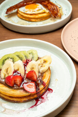 Pancakes with fresh fruit, chocolate spread, and savory pancakes with egg and bacon