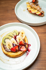 Pancakes with fresh fruit, chocolate spread, and savory pancakes with egg and bacon