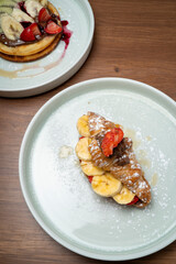 Sweet croissant with fresh fruit and chocolate spread, served with a waffle dessert
