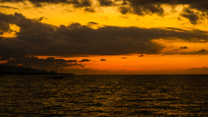 the atmosphere of the beach when the sun sets and the sky looks cloudy