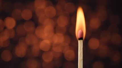 A single lit matchstick with a bright flame against a blurred background of bokeh lights