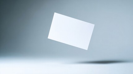 A blank white rectangular sheet floats in midair against a fading gray background, no text or objects visible,