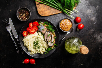 Herring with mashed potatoes tomatoes and mustard on a plate