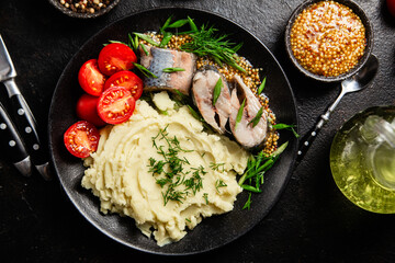 Herring with mashed potatoes tomatoes and mustard on a plate