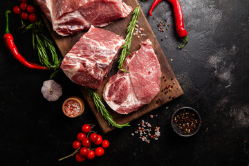 Raw Pork Cuts with Herbs and Spices on a Wooden Board