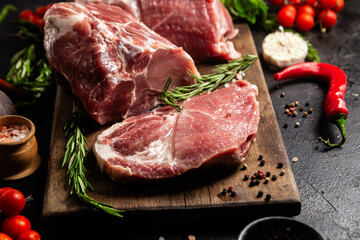 Raw Pork Cuts with Herbs and Spices on a Wooden Board