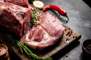 Raw Pork Cuts with Herbs and Spices on a Wooden Board