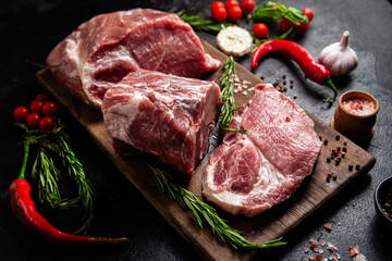 Raw Pork Cuts with Herbs and Spices on a Wooden Board