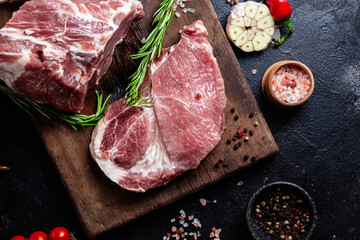 Raw Pork Cuts with Herbs and Spices on a Wooden Board