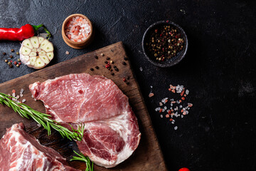 Raw Pork Cuts with Herbs and Spices on a Wooden Board