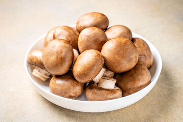 Fresh brown mushrooms in a white bowl