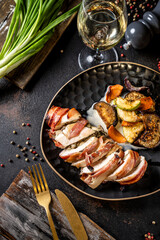 Gourmet bacon wrapped chicken breast with roasted vegetables