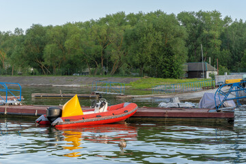 Inflatable rescue boat equipped with steering console. Safe haven for exploration a red inflatable boat rests peacefully at the pier ready to embark on new adventures.