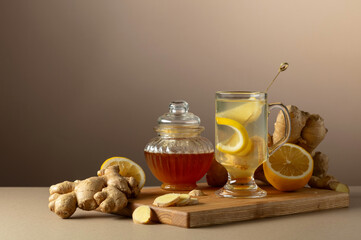 Ginger tea with lemon and honey on a beige background.