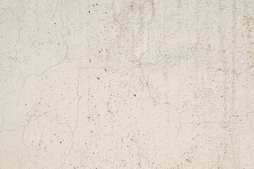A white wall with a lot of holes and cracks