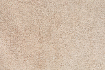 Soft fluffy beige fabric background. Cozy textured surface for design, posters, 3D render, lifestyle mockups, and concepts of comfort, warmth, and home atmosphere