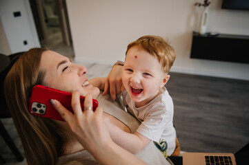 Mother working from home with kid. Quarantine and closed nursery school. Distance learning through war. Child make noise and disturb woman work. Homeschooling and freelance job. Stay at home.