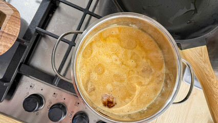 Simmering pot of golden broth conjures hygge vibes, perfect for Lunar New Year feasts or cozy...