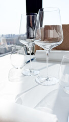Crystalline wine glasses bask in sunlit elegance, whispering secrets of Bacchus festivals and opulent urban rendezvous in sky-bound dining