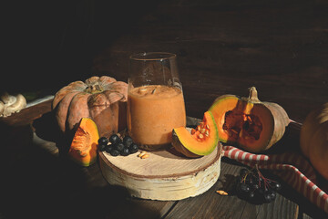 Pumpkin smoothie is a healthy drink. It is healthy and nutritious food for autumn. A vitamin drink made from pumpkin and other vegetables on a rustic background.