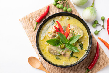 Top view of Thai green curry chicken with ingredients on white background