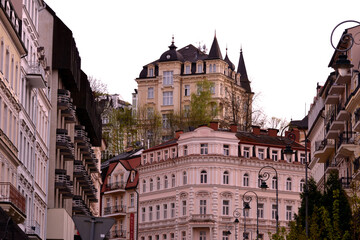 This is a view of Karlovy Vary's streetscape, showing elegant, historical buildings with detailed facades and balconies. The architecture features a mix of styles