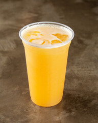 Orange juice with ice in a plastic cup