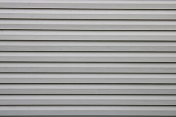 Bardage lame composite blanc gris sur la façade de la maison