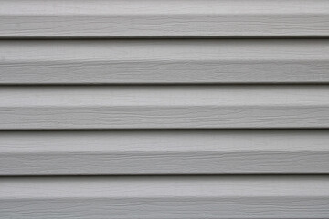 Bardage lame composite blanc gris sur la façade de la maison