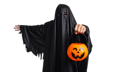 A person dressed as a ghost holding a jack-o'-lantern