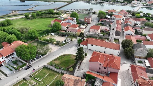 Historic coastal town Nin captured by drone in spring. Old town Nin with stone houses and Adriatic backdrop filmed from above, showing heritage and coastal charm in springtime Croatia