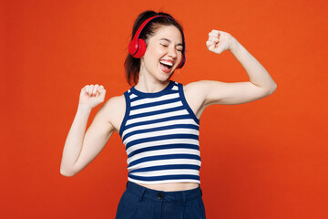 Young smiling woman she wears blue striped tank top casual clothes listen to music in headphones...