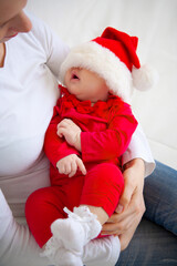 Portrait of Christmas baby is lying on mother’s hands