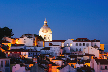 Panoramic Night View Over Alfama’s Rooftops and Tagus River from Miradouro da Graca Viewpoint in Lisbon, Portugal