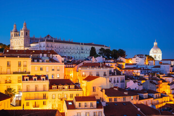 Panoramic Night View Over Alfama’s Rooftops and Tagus River from Miradouro da Graca Viewpoint in Lisbon, Portugal