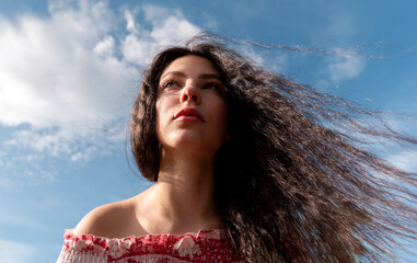 Beautiful brunette portrait under the blue sky, low angle view