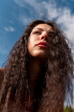 Beautiful young woman portrait under the blue sky, low angle view