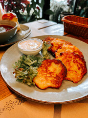 Delicious potato pancakes served with sauce and salad in a cozy cafe setting
