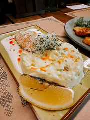 Flavorful dish featuring grilled fish and creamy sauce served on a stylish plate