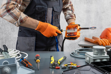 Electrician work to connect electric wires in electrical box.