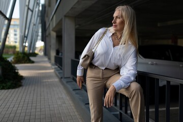 Fototapeta premium Woman posing casually in modern urban setting with stylish attire and a relaxed expression