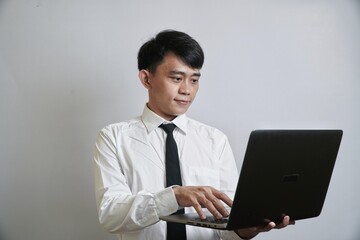 Asian Professional Man Using Laptop, Focused on Work, Modern Technology in Office