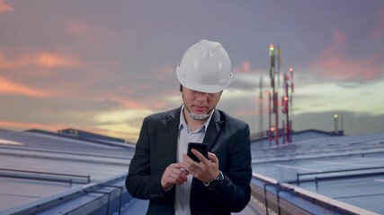 Front View of Asian Businessman Use Smartphone While Walking at Industrial Rooftop Solar Panels - Powered by Adobe