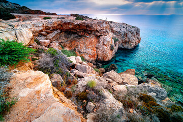Panorama rocky coast Cape Greco, Cyprus, in morning. Famous site near Ayia Napa, Crow's Arch. Sunrise on Mediterranean island.