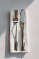 Silver fork and knife rest elegantly on a crisp napkin, evoking culinary anticipation, resembling Thanksgiving feasts and Hygge moments