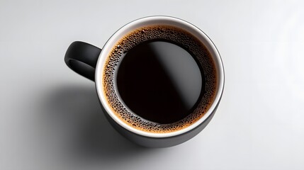 Fototapeta premium A close-up view of a ceramic mug filled with freshly brewed, aromatic black coffee, set against a simple, minimalist white background.