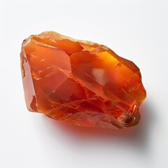 A vibrant, translucent orange gemstone with irregular facets and a rough texture rests on a stark white background.  Its rich color and crystalline structure are clearly visible