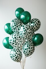 A cluster of emerald green and white leopard print balloons against a white background.  The balloons are glossy and appear to be inflated
